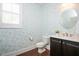 A powder room with floral wallpaper, a round mirror, and dark cabinets at 800 Laurel Garden Way, Cary, NC 27513
