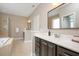 A primary bathroom with double sinks, a dark vanity, and a glass-enclosed shower at 800 Laurel Garden Way, Cary, NC 27513