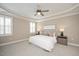 A bedroom with a ceiling fan, tray ceiling, carpet, and neutral color scheme at 800 Laurel Garden Way, Cary, NC 27513