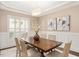 Elegant dining room with hardwood floors, wainscoting, neutral walls, and a modern light fixture at 800 Laurel Garden Way, Cary, NC 27513