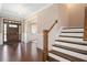 A foyer with a staircase, hardwood floors, and a dark wood front door at 800 Laurel Garden Way, Cary, NC 27513