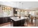 Gourmet kitchen with granite countertops, a large island, stainless steel appliances, and dark wood cabinetry at 800 Laurel Garden Way, Cary, NC 27513