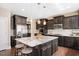 Spacious kitchen with dark wood cabinets, granite countertops, stainless steel appliances, and a large island at 800 Laurel Garden Way, Cary, NC 27513