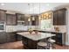 Open concept kitchen with a center island, dark cabinets, granite countertops, and pendant lighting at 800 Laurel Garden Way, Cary, NC 27513