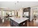 Kitchen island with seating, granite countertops, dark cabinets, and stainless steel appliances in an open layout at 800 Laurel Garden Way, Cary, NC 27513