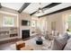 A bright living room with a fireplace, built-in shelves, ceiling fan, and wooden beams at 800 Laurel Garden Way, Cary, NC 27513