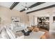 A living room with a ceiling fan, wooden beams, and an open floor plan to the kitchen at 800 Laurel Garden Way, Cary, NC 27513
