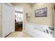 Bathroom showcasing a soaking tub with jets, tile floors, and doorway to the Primary bedroom at 8308 Buck Crossing Dr, Durham, NC 27713