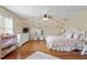 Cozy bedroom features floral accent wall, wood floors, ceiling fan, and modern furnishings at 8308 Buck Crossing Dr, Durham, NC 27713