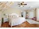 Bright bedroom featuring floral accent wall, wood floors, ceiling fan, and a comfortable bed at 8308 Buck Crossing Dr, Durham, NC 27713