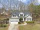 Charming home featuring a two-car garage, manicured lawn, and mature trees at 8308 Buck Crossing Dr, Durham, NC 27713