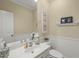 Charming powder room featuring a pedestal sink, decorative mirror, and neutral color palette at 8308 Buck Crossing Dr, Durham, NC 27713