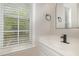 Well-lit bathroom featuring natural light, a stylish faucet, and modern mirror at 9332 Carley Cir, Garner, NC 27529