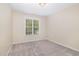 This bedroom features neutral walls, carpet flooring, a ceiling light fixture, and a window that provides ample natural light at 9332 Carley Cir, Garner, NC 27529