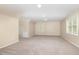 An oversized bonus room with neutral walls, carpet flooring, multiple windows, and ceiling lights offers versatile possibilities at 9332 Carley Cir, Garner, NC 27529