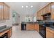 Open concept kitchen features light wood cabinets and black appliances at 1008 Double Spring Ct, Apex, NC 27502