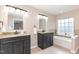 Bathroom features a double vanity, large mirrors, granite countertops and a soaking tub with tile backsplash at 103 Woolard Way, Apex, NC 27502