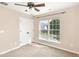 Bedroom featuring carpet, a window overlooking the street, and a closet with double doors at 103 Woolard Way, Apex, NC 27502