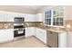 Modern kitchen with stainless steel appliances, granite countertops, and white cabinetry at 103 Woolard Way, Apex, NC 27502