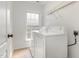 Bright laundry room with a window, tile floors, a washer and a dryer at 103 Woolard Way, Apex, NC 27502