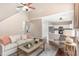 Open-concept living room featuring hardwood floors, a ceiling fan, view of kitchen and stairs to the second floor at 103 Woolard Way, Apex, NC 27502