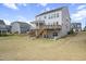 Expansive backyard with a lush lawn, a deck with stairs, and a swing set, perfect for outdoor fun at 105 Smoky Emerald Way, Holly Springs, NC 27540