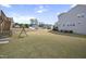 Expansive backyard featuring a well-maintained lawn and swing set with steps leading to deck at 105 Smoky Emerald Way, Holly Springs, NC 27540