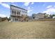 Spacious backyard with a lush lawn, a deck with stairs, and a swing set, ready for outdoor activities at 105 Smoky Emerald Way, Holly Springs, NC 27540