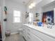 Bathroom with double sinks, a large mirror, neutral walls, and natural light from the window at 105 Smoky Emerald Way, Holly Springs, NC 27540