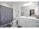 Bathroom with a shower/tub combo, vanity, and a large mirror providing a glimpse into bedroom at 105 Smoky Emerald Way, Holly Springs, NC 27540