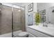 Clean bathroom featuring a tiled walk-in shower, white vanity, and decorative accents at 105 Smoky Emerald Way, Holly Springs, NC 27540