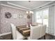 Elegant dining room featuring a patterned accent wall, stylish chandelier, and a modern wooden table at 105 Smoky Emerald Way, Holly Springs, NC 27540