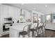 Bright kitchen features white cabinets, stainless steel appliances, and a large island with seating at 105 Smoky Emerald Way, Holly Springs, NC 27540