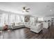 Large, inviting living room with hardwood floors, a sectional sofa, and ample natural light that flows into the kitchen at 105 Smoky Emerald Way, Holly Springs, NC 27540