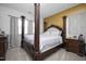 Bedroom with a four-poster bed, neutral walls, patterned wallpaper, and side tables at 105 Smoky Emerald Way, Holly Springs, NC 27540