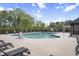 Inviting community pool area with lounge chairs, a lifeguard stand, and surrounded by mature trees at 105 Smoky Emerald Way, Holly Springs, NC 27540