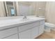 Bathroom vanity features white cabinets, single sink and mirror, complemented by neutral patterned wallpaper at 1054 Weathervane Hill Dr, Rocky Mount, NC 27803