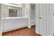 Bathroom features double sink vanity with white cabinets, wood floor and tub/shower combo at 1054 Weathervane Hill Dr, Rocky Mount, NC 27803