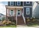 Close-up of a home's inviting front porch with wooden steps and decorative landscaping details at 109 Broadwater Dr, Wake Forest, NC 27587