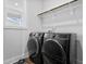 Modern laundry room with sleek, dark front-loading washer and dryer appliances at 109 Broadwater Dr, Wake Forest, NC 27587