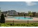 Community pool with zero entry, chairs, and lounge area, enclosed by a black fence at 109 Broadwater Dr, Wake Forest, NC 27587