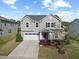 Charming two-story home featuring a two-car garage and manicured landscaping with a young tree in the front yard at 109 Oak Rise Ln, Fuquay Varina, NC 27526