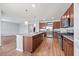 Well-lit kitchen with a center island, granite countertops, stainless steel appliances, and dark wood cabinets at 109 Oak Rise Ln, Fuquay Varina, NC 27526