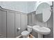 Charming powder room featuring elegant wallpaper, a pedestal sink, wainscoting, and a round mirror at 109 Oak Rise Ln, Fuquay Varina, NC 27526
