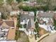 Aerial view of home with snow-dusted roof, manicured landscaping, long driveway, and neighborhood setting at 109 Yorkchester Way, Raleigh, NC 27615
