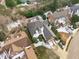 Aerial view of home with snow-dusted roof, manicured landscaping, long driveway, and neighborhood setting at 109 Yorkchester Way, Raleigh, NC 27615