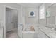 A soaking tub is surrounded by granite countertops, with natural light from a nearby window at 109 Yorkchester Way, Raleigh, NC 27615