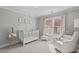 Neutral Bedroom with crib, white rocking chair, soft accents, and large window at 109 Yorkchester Way, Raleigh, NC 27615