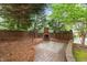 Private backyard with brick fireplace, patio, and mature landscaping at 1104 Hobson Ct, Raleigh, NC 27607
