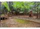 Backyard featuring a brick outdoor fireplace, stone patio, and mature trees at 1104 Hobson Ct, Raleigh, NC 27607
